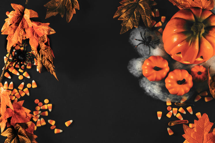 Halloween themed background with pumpkins, spiders, and candycorn