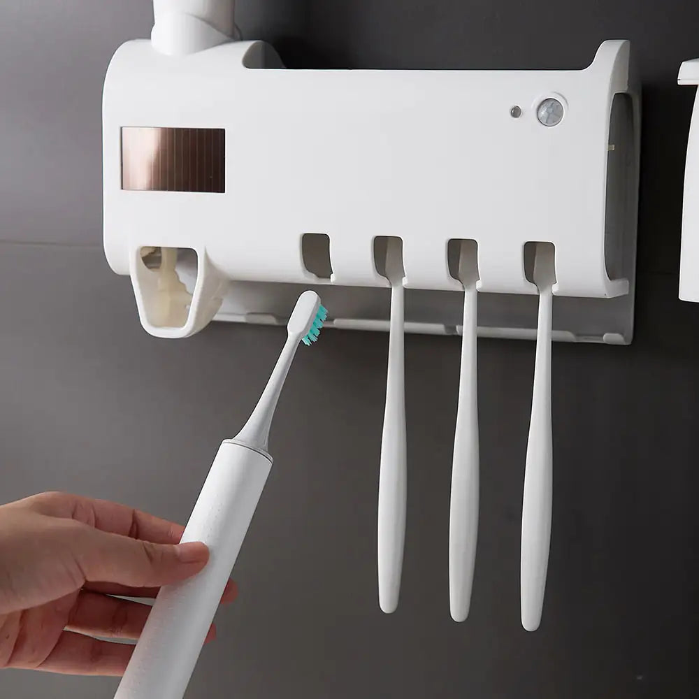 person placing a toothbrush into the Automatic Toothpaste Dispenser