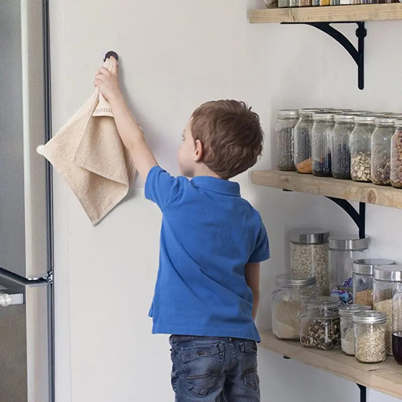 a boy placing a towel into a Wall Mount Towel Holder