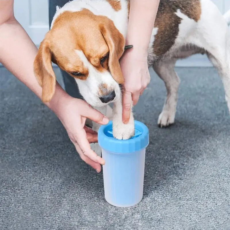 owner placing a dog's paw in a blue Pet Paw Cleaner Cup