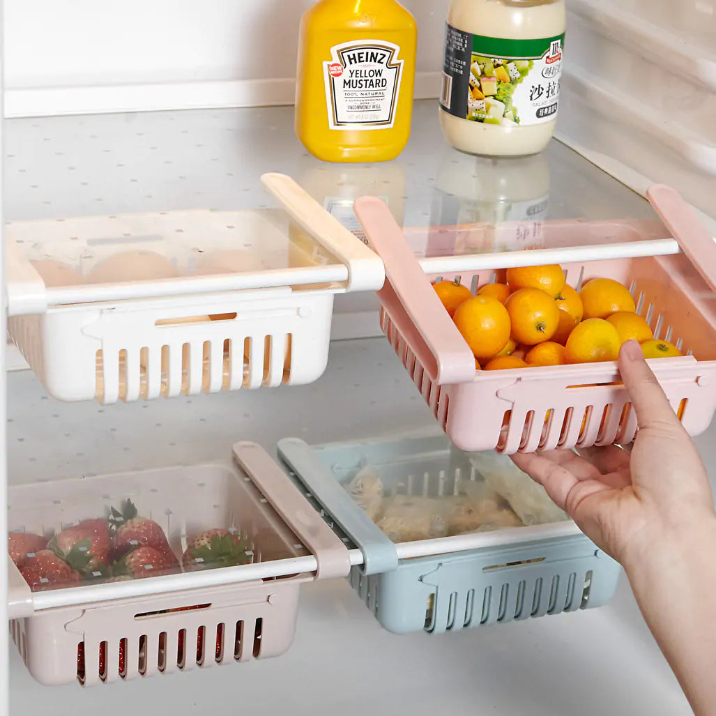woman pushing a Refrigerator Storage Drawer filled with oranges into the refrigerator