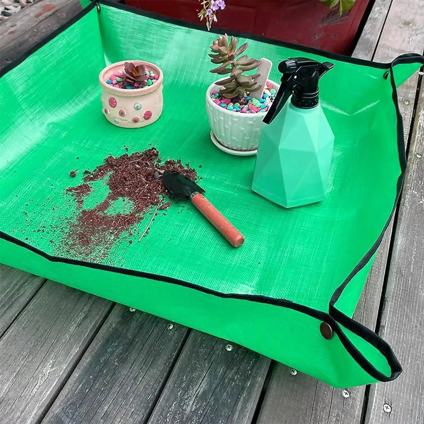 Waterproof Gardening Mat with a spray bottle, shovel, and dirt