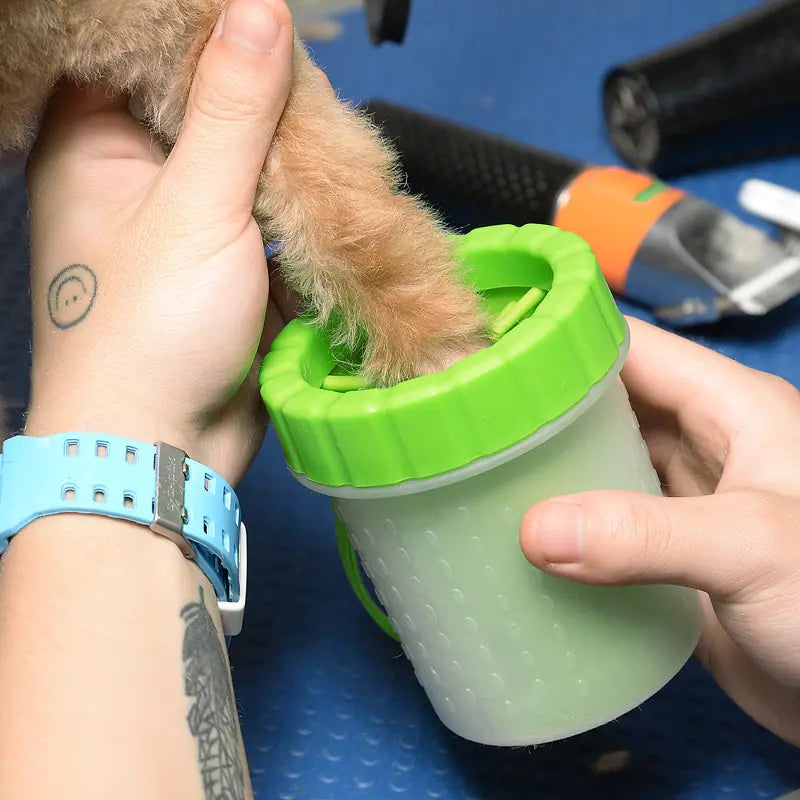 dog's paw in a green Pet Paw Cleaner Cup