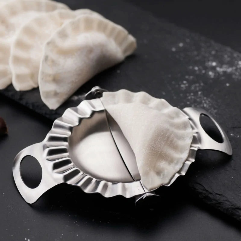 Stainless Steel Dumpling Mold with dumplings on a cutting board